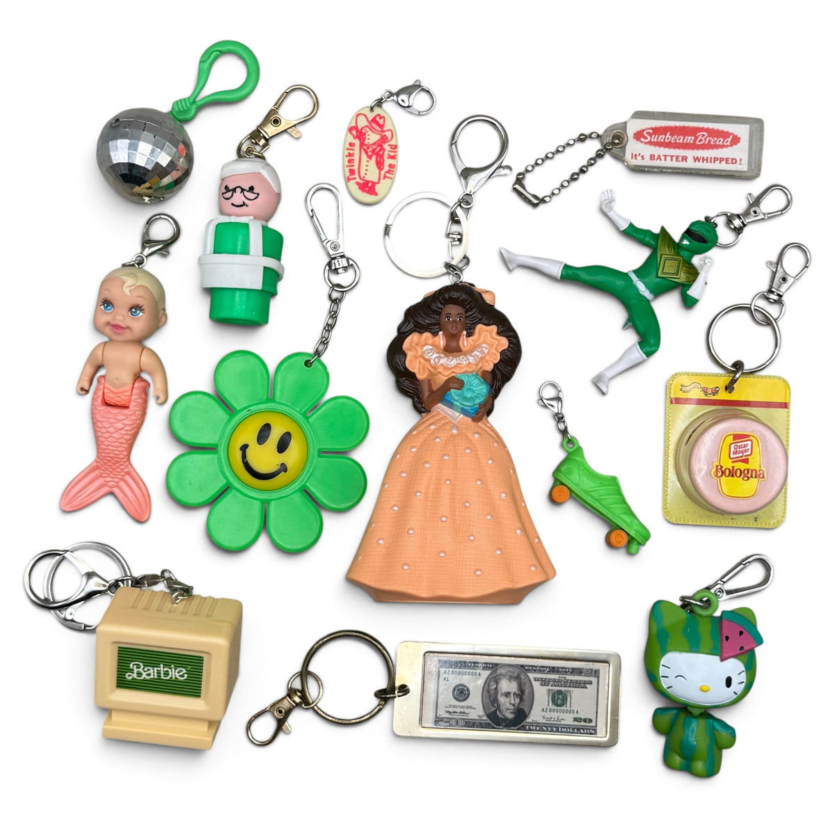 Green keychain assortment featuring Birthday Surprise Barbie, Tyco MerBaby, Twinkie the Kid, Hello Kitty and advertising charms.