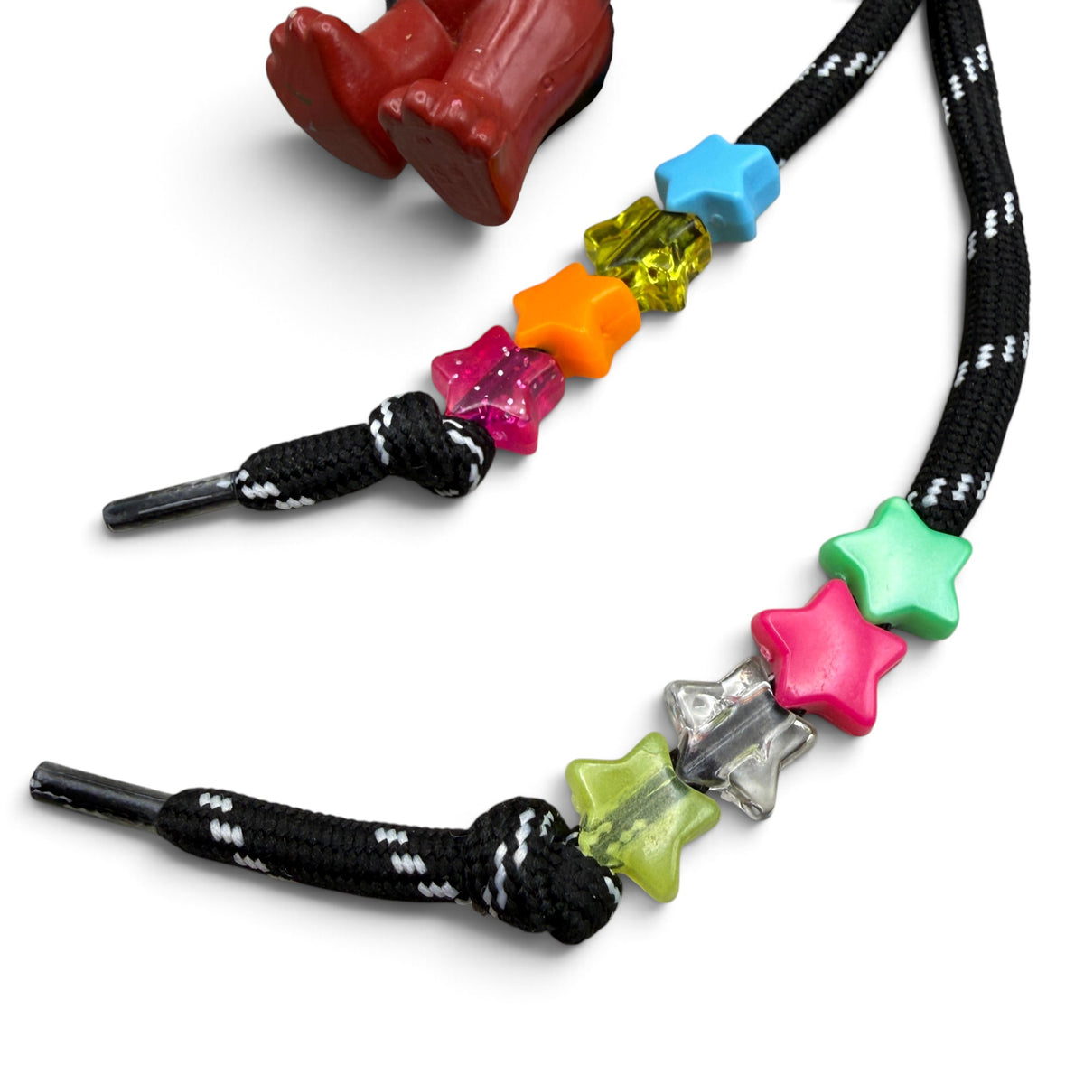 Multicolor star beads knotted on black-and-white paracord tails of the Lisa Frank bear charm set