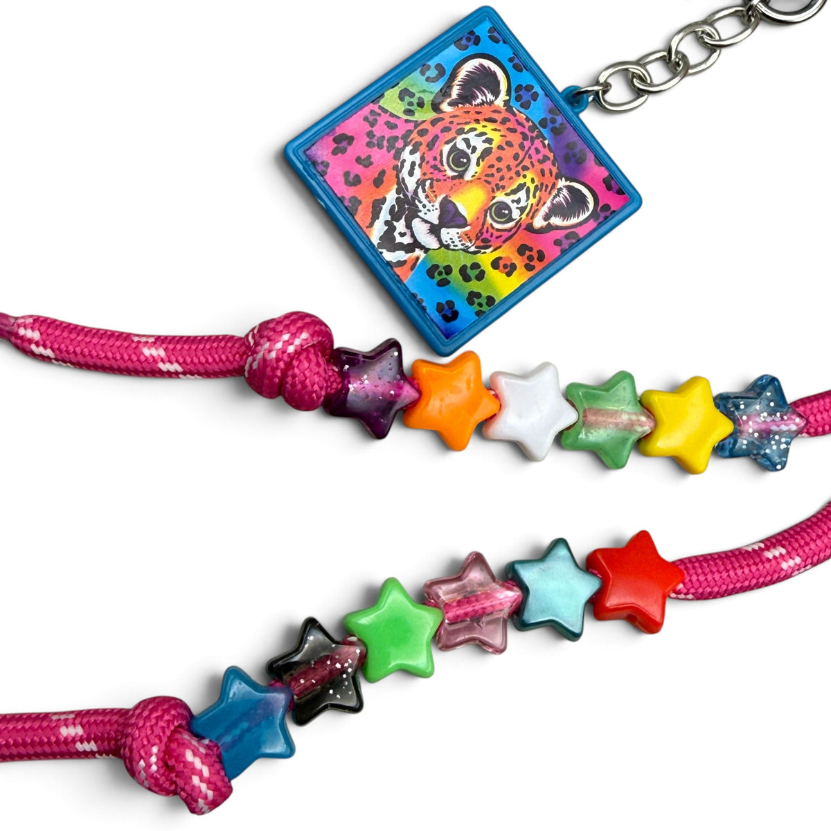 Close-up of the Lisa Frank leopard cub square keychain and multicolor star beads on pink paracord