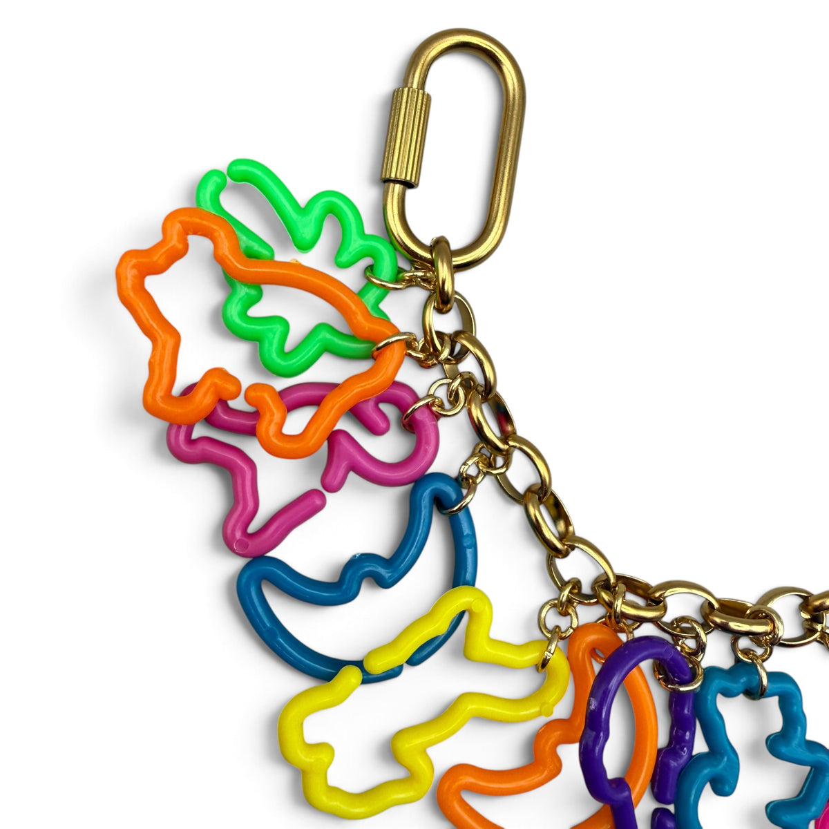 Close-up of neon Lisa Frank cutout shapes hanging from the gold-plated rolo chain by a twist carabiner