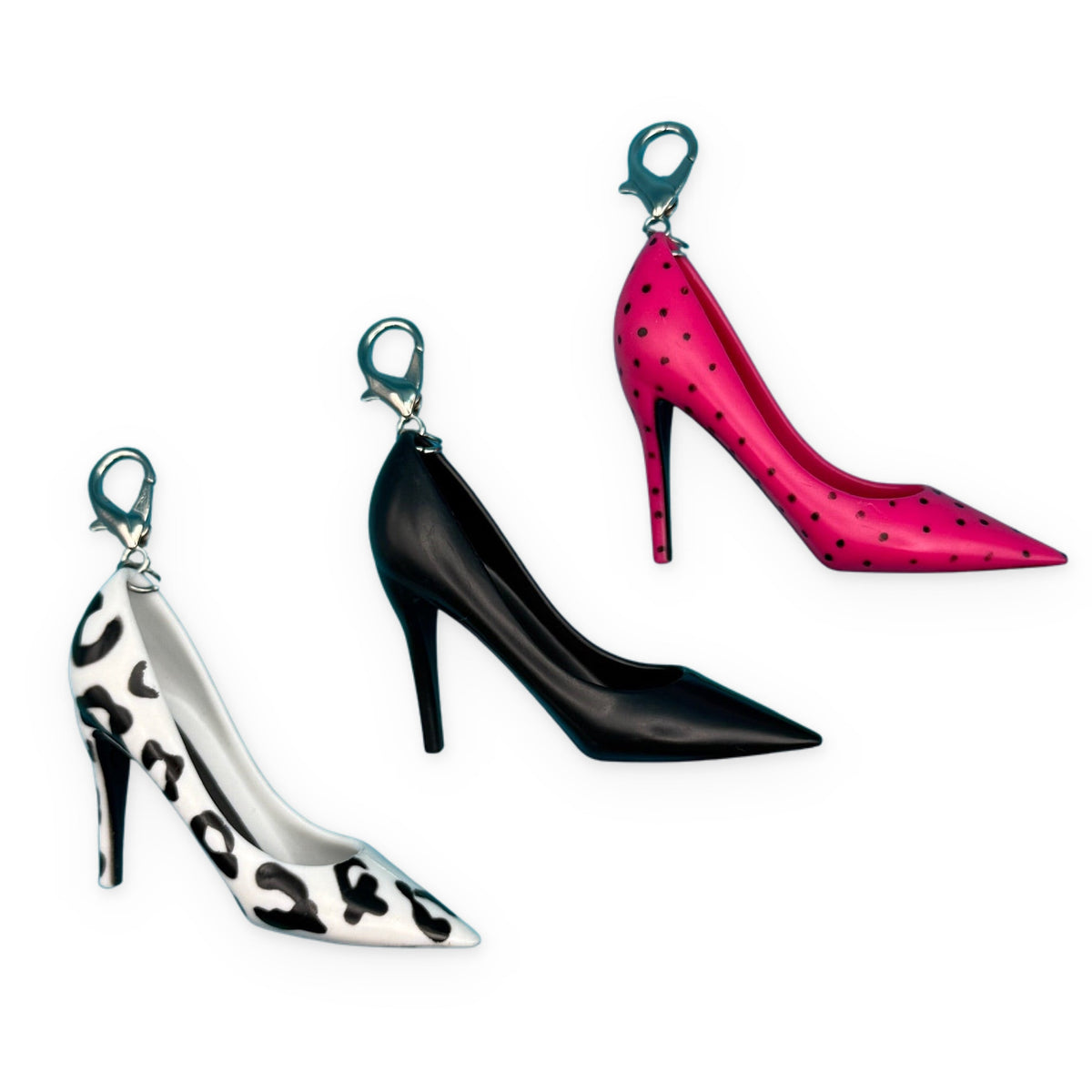 Three high-heeled shoe keychains on a blue background
