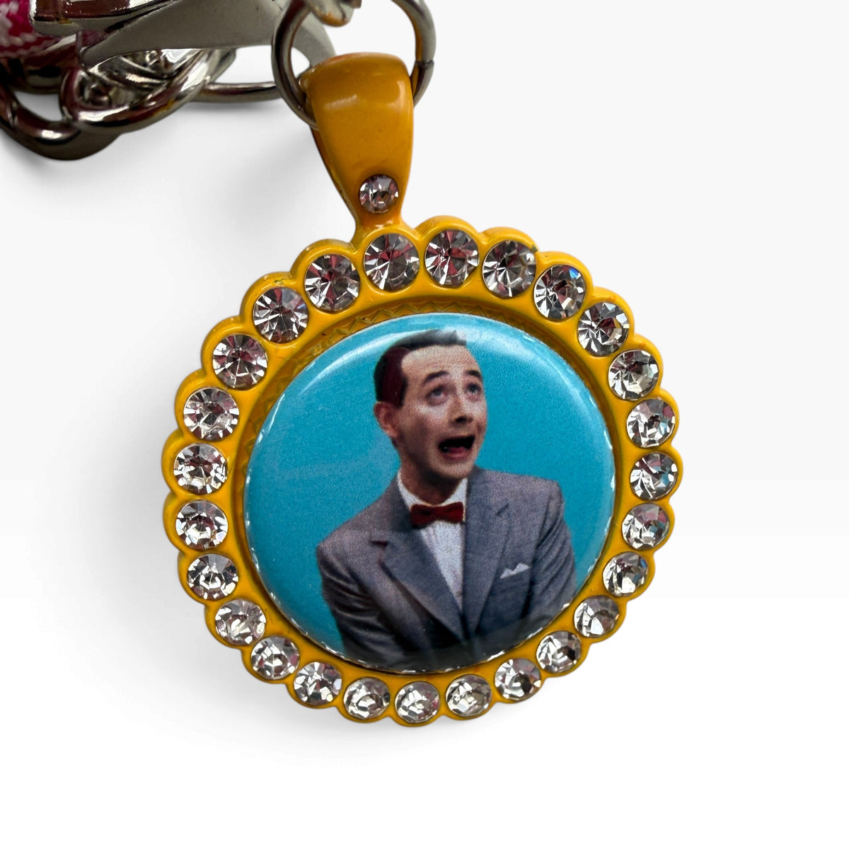 Close-up of the rhinestone-framed Pee-wee Herman portrait charm