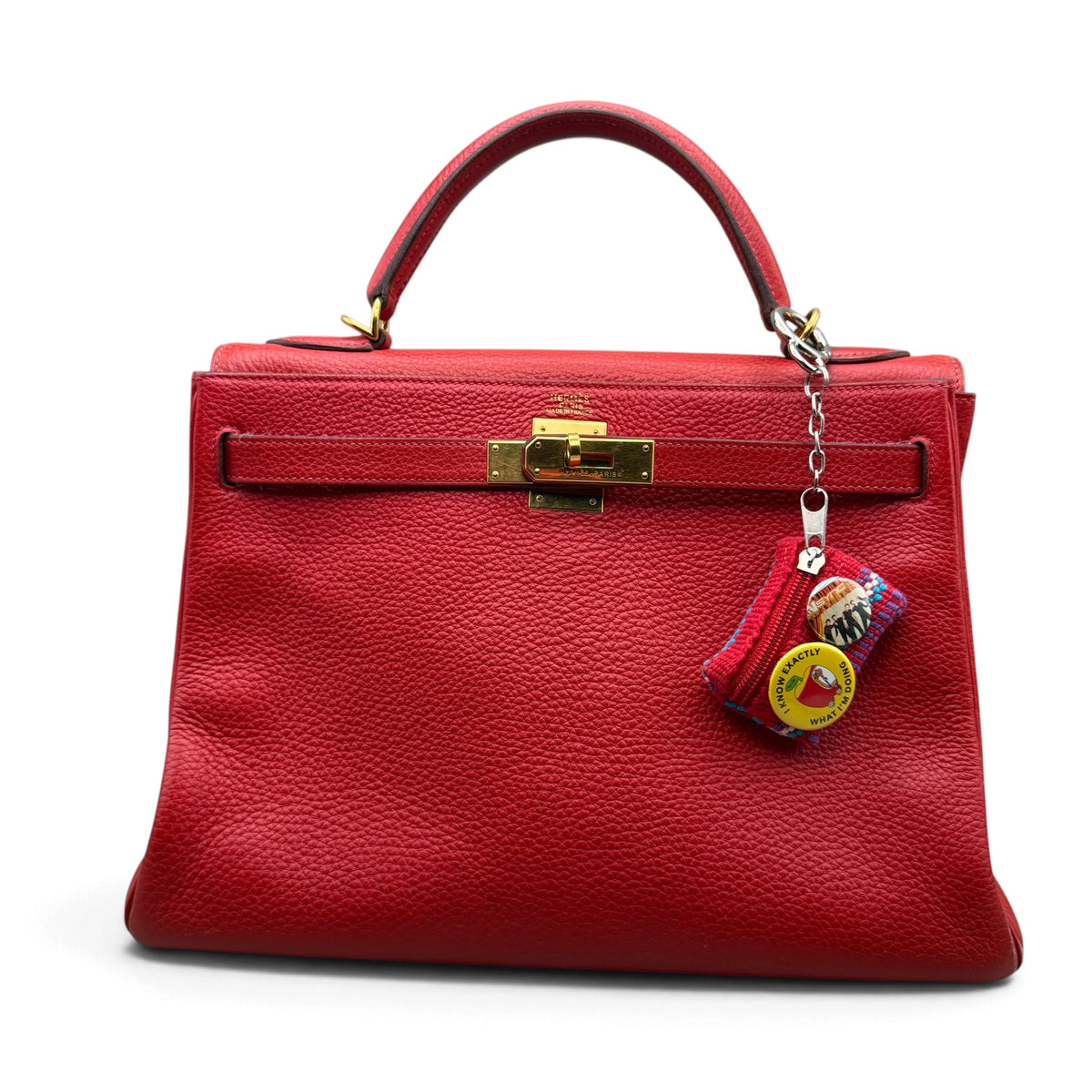 Red woven novelty phrase mini pouch charm styled on a red handbag